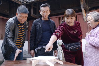 Mr John Lin (second from left) discussing the design options of renovating Tulou with the local residents