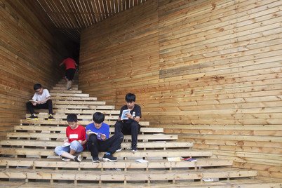 Children gathering at the sheltered steps of the ‘Plug-in’ which connects to the book corner of Tulou