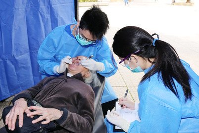 牙科学生在成人检查摊位提供口腔检查服务