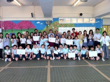 Primary school participants (front) showing their artworks at the end of the orientation day with their mentors (back)