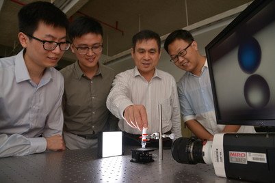 Professor Liqiu Wang (third from left) and his team demonstrate droplet manipulation using liquid-repellent materials