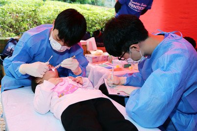 牙科学生在儿童检查摊位提供口腔检查及氟化物治疗服务