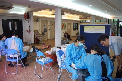 盧展民教授（右）監督牙醫學生為參與者進行牙齒檢查