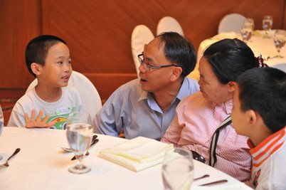 Two primary school participants (at sides) reflecting to their mother and Prof. Yip what they learned in the problem-solving skills workshop